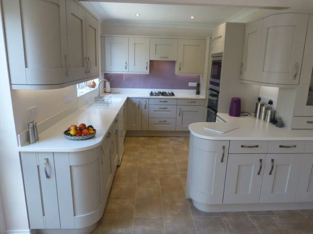 Cream shaker kitchen with curved end units and white worktops